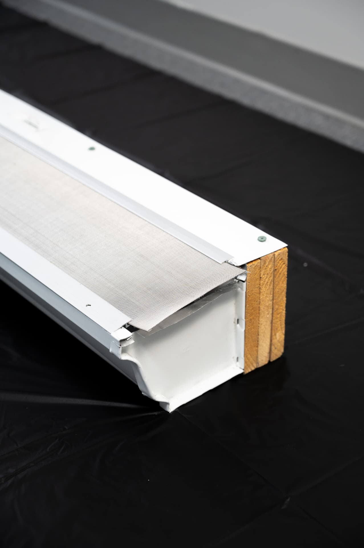Cross-section showing the Gutter Goddess guard pressure-fitted at the roof edge and secured to the gutter lip